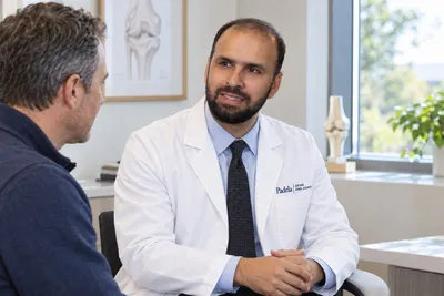 Dr. Padela talking with a patient in an exam room